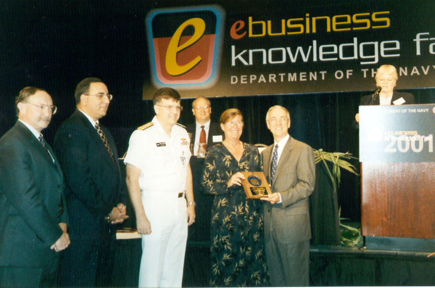 (From left to right) Paul Smith, Pat Tamburrino, Vice Admiral Pete Nanos, and Kathleen Monahan receive a 2001 Department of Navy eGov Award from The Honorable Gordon R. England, Secretary of the Navy.